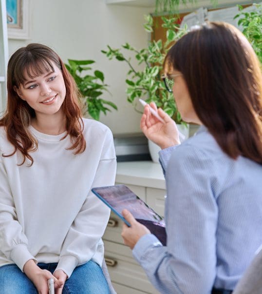 Two women talking in a bright office.