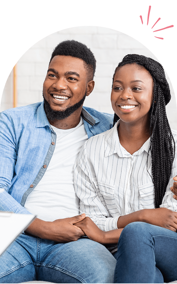 Smiling couple sitting on a couch together.
