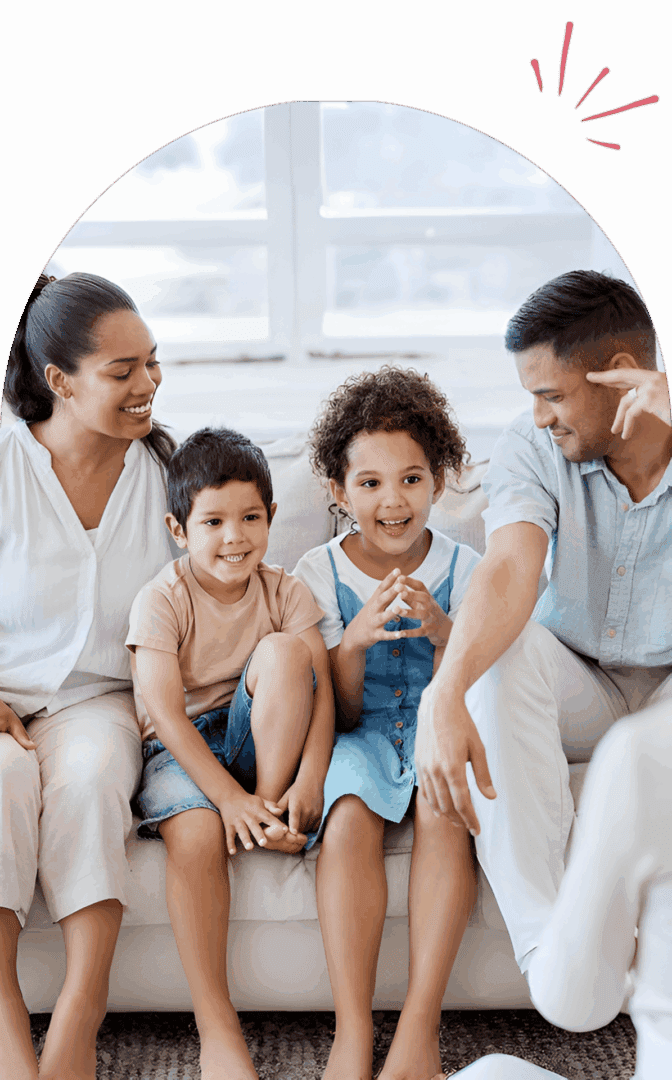 Family sitting together on a couch, smiling.
